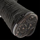 The hardwood handle is wrapped in genuine, white rayskin and black cord and the tsuba is metal alloy in a golden dragon design