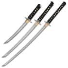 Three swords with carbon steel blade and black nylon cord wrapped handles. 