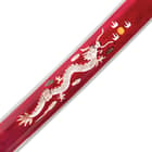Detailed view of the mother-of-pearl dragon on the side of the red scabbard. 