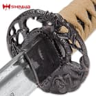 Close view custom cast macaque monkey tree tsuba with a peek of damascus steel blade
