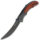 Open shinwa shinigami bloodwood pocket knife with raindrop pattern blade, metallic blue accents, and engraved bloodwood handle scales. 
