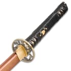 View of shinwa katana showcase the copper finish blade leading to brass habaki and handguard attached to leather wrapped grip
