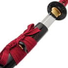 The 40” overall katana slides smoothly into a piano lacquered scabbard, accented with red cord-wrap to match the handle
