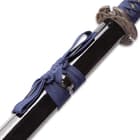 A blue hanging cord is wrapped around the black scabbard. 