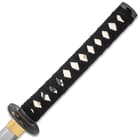 Zoomed view of the white imitation ray skin handle wrapped in black cord with menuki. 