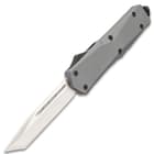 Release the knife’s blade using the black lever on the spine of the grey metal alloy handle.