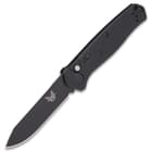 Open benchmade mediator automatic knife with non-reflective black steel blade and G10 handle.
