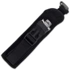 Closed switchblade enclosed in black nylon belt sheath with open buckle closure. 

