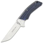 Angled view of extended pocket knife with a shining silver double edged blade and blue and black handle. 
