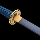 Damascus steel blue blade with brass habaki under cast metal handguard extended to red rayskin handle wrapped with blue cord

