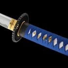 The hardwood handle is wrapped in faux rayskin and blue cord and has an intricately detailed metal alloy tsuba