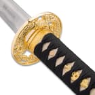 Shinwa sword with direct view of gold like cast metal hand guard leading to a genuine rayskin handle wrapped with black sageo
