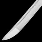 Closeup of the curved edge of the Damascus steel katana blade. 