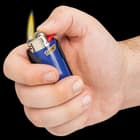 Hand holding black pocket knife lighter caddy containing blue "BIC" lighter that has been lit by the hand's thumb. 
