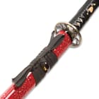 Sword with rayskin tsuka in red lacquered saya with sparkles and black cord wrapped at the base through the brass shito-dome
