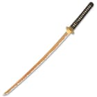 The keenly sharp, 28” blade is hand-forged of 1060 carbon steel with a burned finish and brown coating, and it extends from an engraved brass habaki