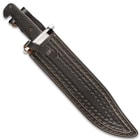 Large knife in a dark brown leather sheath with various intricate stamped details and a snap button closure.
