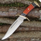The knife’s handle is made of pakka wood and has a brass guard, pommel, and pins.