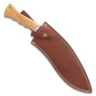 The kukri knife can be secured inside its included brown leather sheath with white stitching.