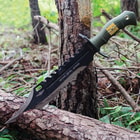 The bowie knife’s blade with sawback spine is shown stuck into a tree trunk.