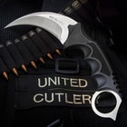 The 4” karambit with its textured handle and curved stainless steel blade is shown on a tactical background.