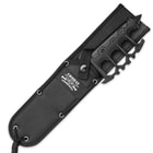 The knife is shown secured into a nylon sheath with grommets.