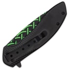It has black, aluminum handle scales with a 3D printed wood facing that has green and black Celtic knot themed artwork
