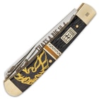The bone handle is done in black with a yellow firebird, accented with a jigged bone panel and a white band, separated by brass spacers