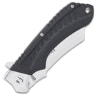 The knife has handle scales made of black G10 with deep ridges and a lanyard hole.