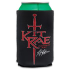 A can is shown inside a black koozie printed with red Kit Rae logo with sword image and Kit Rae’s signature in white.