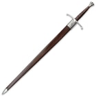 Claymore sword comes encased in a brown leather scabbard with a metal steel handguard and steel polished accents
