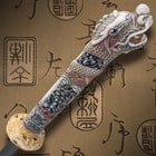 View from the top of the faux ivory handle with intricate designs and dragon head. 