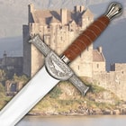 The handle of the broadsword is wrapped with brown leather and wire with an intricate crossguard with “Macleod” on it.  