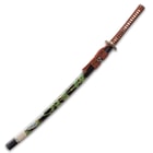 The glossy black scabbard has a bright green bamboo design on the side with brown hanging cord. 