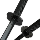Zoomed view of the black-coated tsuba and black imitation ray skin handle wrapped with black nylon cord. 