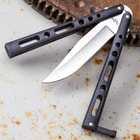 The stainless steel clip point blade is shown between the two skeletonized flippers of the butterfly knife.