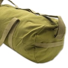 It can be carried by its two nylon webbing handles, a handle on one end and its heavy-duty, nylon webbing shoulder strap