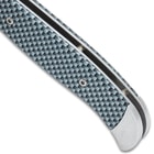 Detailed view of the texture of the Quick Silver Automatic Knife’s carbon fiber handle.