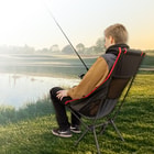 Full image of a person sitting and fishing in the Camp Chair.
