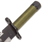 Detailed view of the green cord wrapped handle with built-in compass.