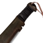 Detailed view of the black cord wrapped machete handle with lanyard hole.
