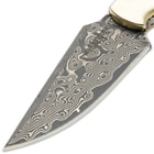 Detailed view of the Damascus steel blade with its intricate design pattern.
