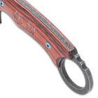 The handle scales are crafted of pakkawood, secured with heavy-duty screws, and the handle has an open-ring pommel