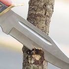 Detailed view of the knife’s 7 1/2" blade striking a tree.