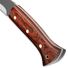 Detailed view of the dark wooden handle scales secured to the tang with brass pin and with brass lanyard hole.