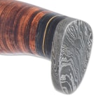 The handle is crafted of leather bands, accented with black wooden bands and brass spacers, and the pommel is Damascus