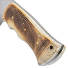 The handle scales are natural bone, expertly carved with a Samburu leaf design, secured with brass pins and it has a brass lanyard hole