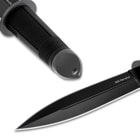 Detailed view of the black stainless steel pommel with lanyard hole and black stainless steel double-edged blade.