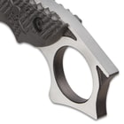 The full-tang blade has thumb notches and extends into a karambit-style open-ring pommel with fighting spurs