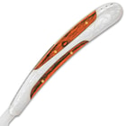 The sleekly curved handle features premium wooden inlays in decoratively etched handle scales with a polished finish